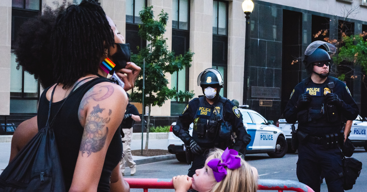 Protesters kept back by police. Photo by Gayatri Malhotra on Unsplash.