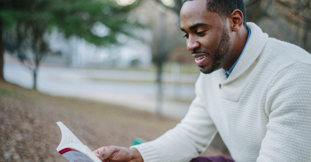 Black teacher reading a book.