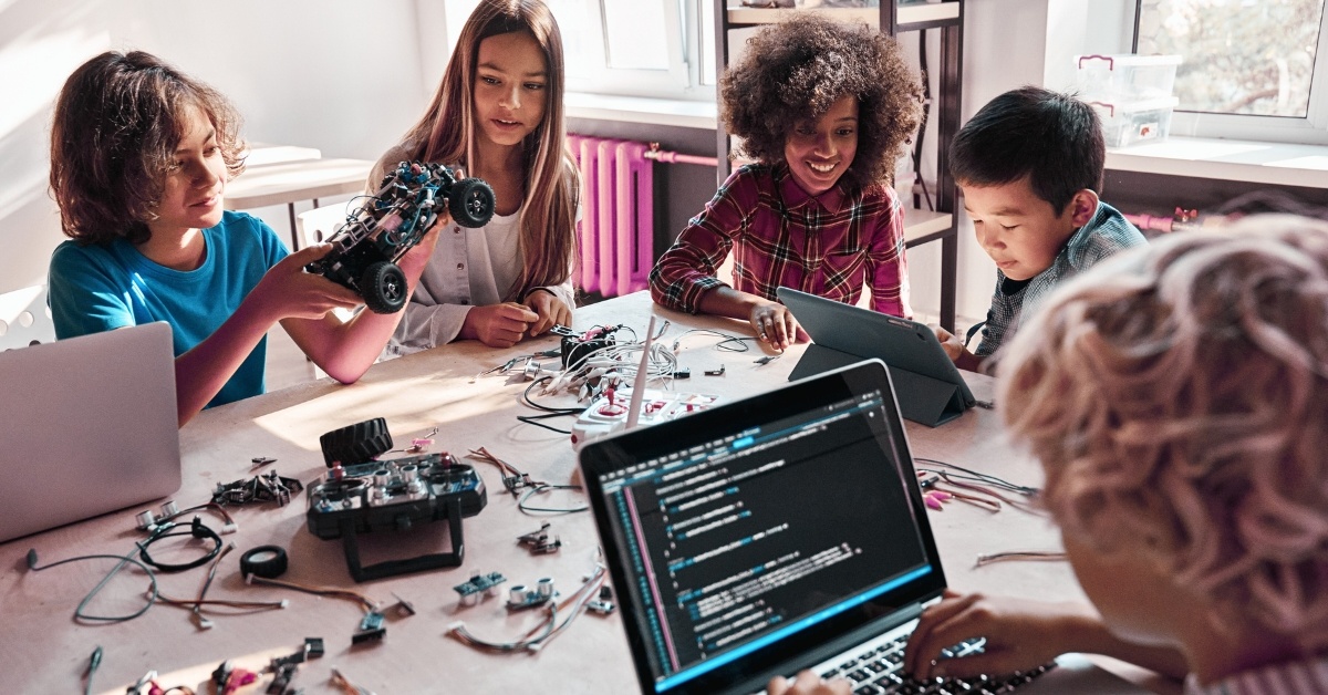 Diverse School Children Students Build Robotic Cars Using Computers and Coding.