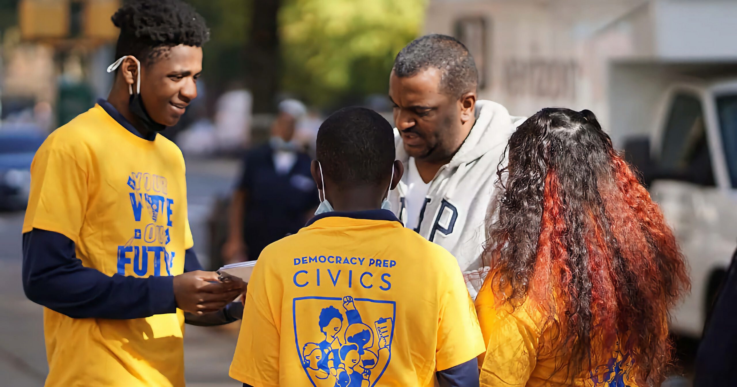 Three young Black Democracy Prep students engaging in a voter registration drive.