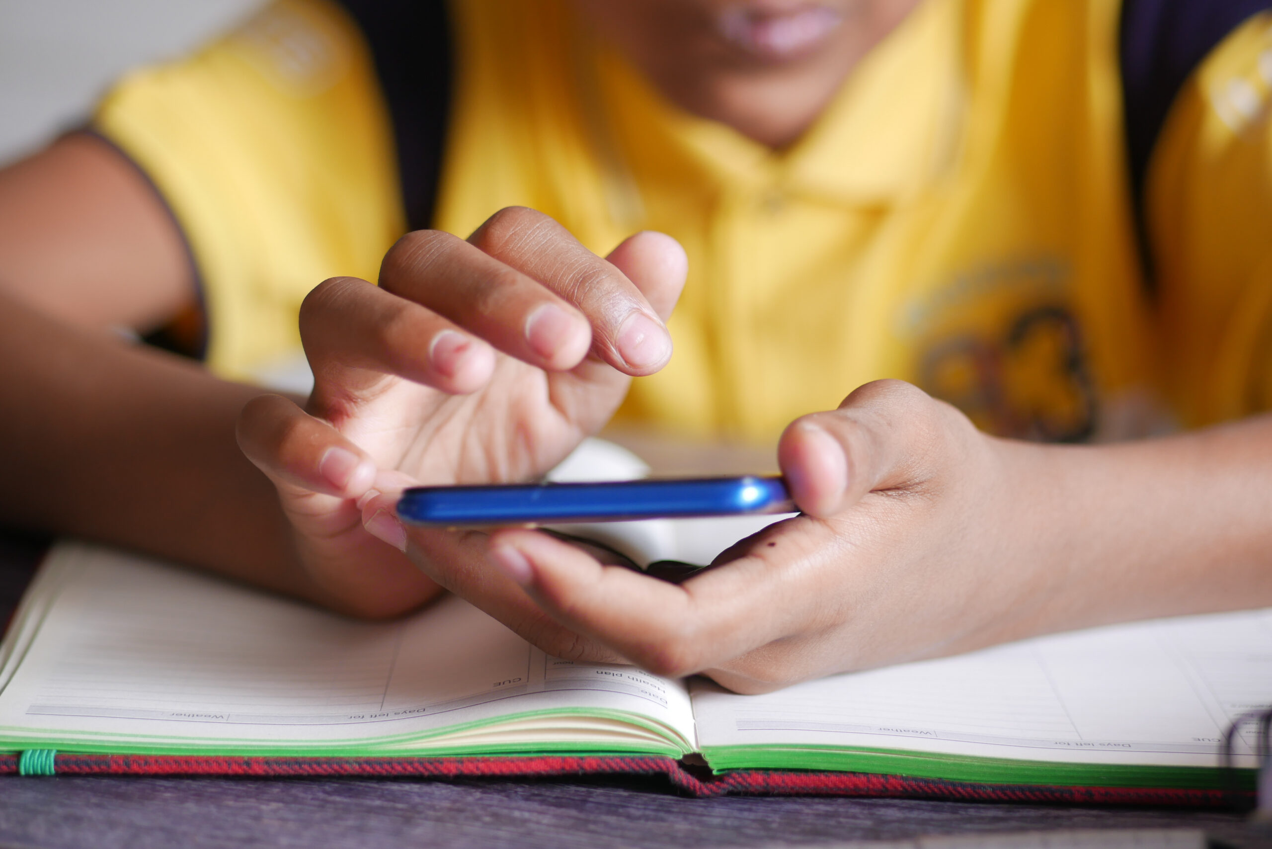 Child hand pointing finger on smart phone screen.