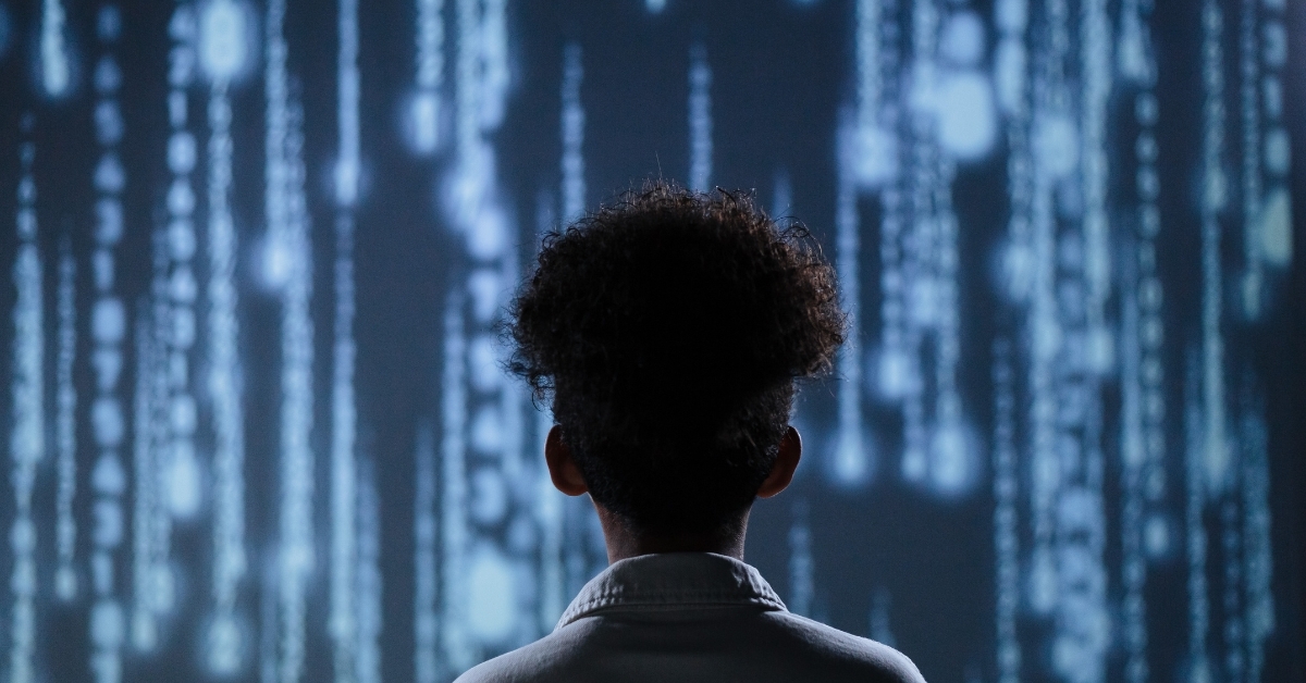 Black child in from of computer language lit up in bright blue lights