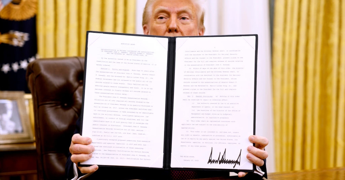 Donald Trump holding up an executive order signed with a Sharpie